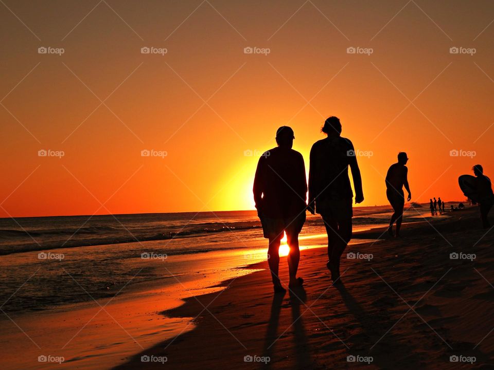 Watching the sunset, gulf of mexico - people in silhouette watching a brilliant sunset over the water of the Gulf of Mexico beach in December