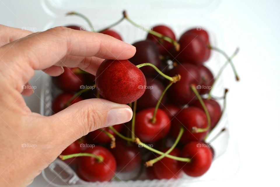 cherry on a white background top view healthy summer food, holding