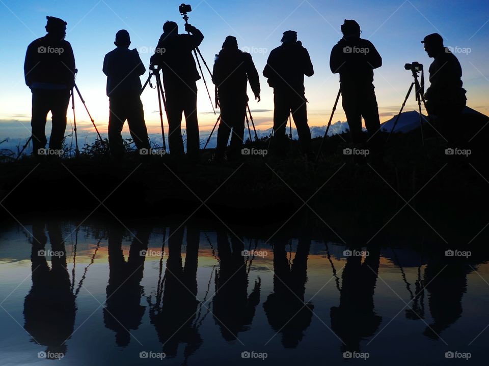 A group of photographers taking photos of sunset