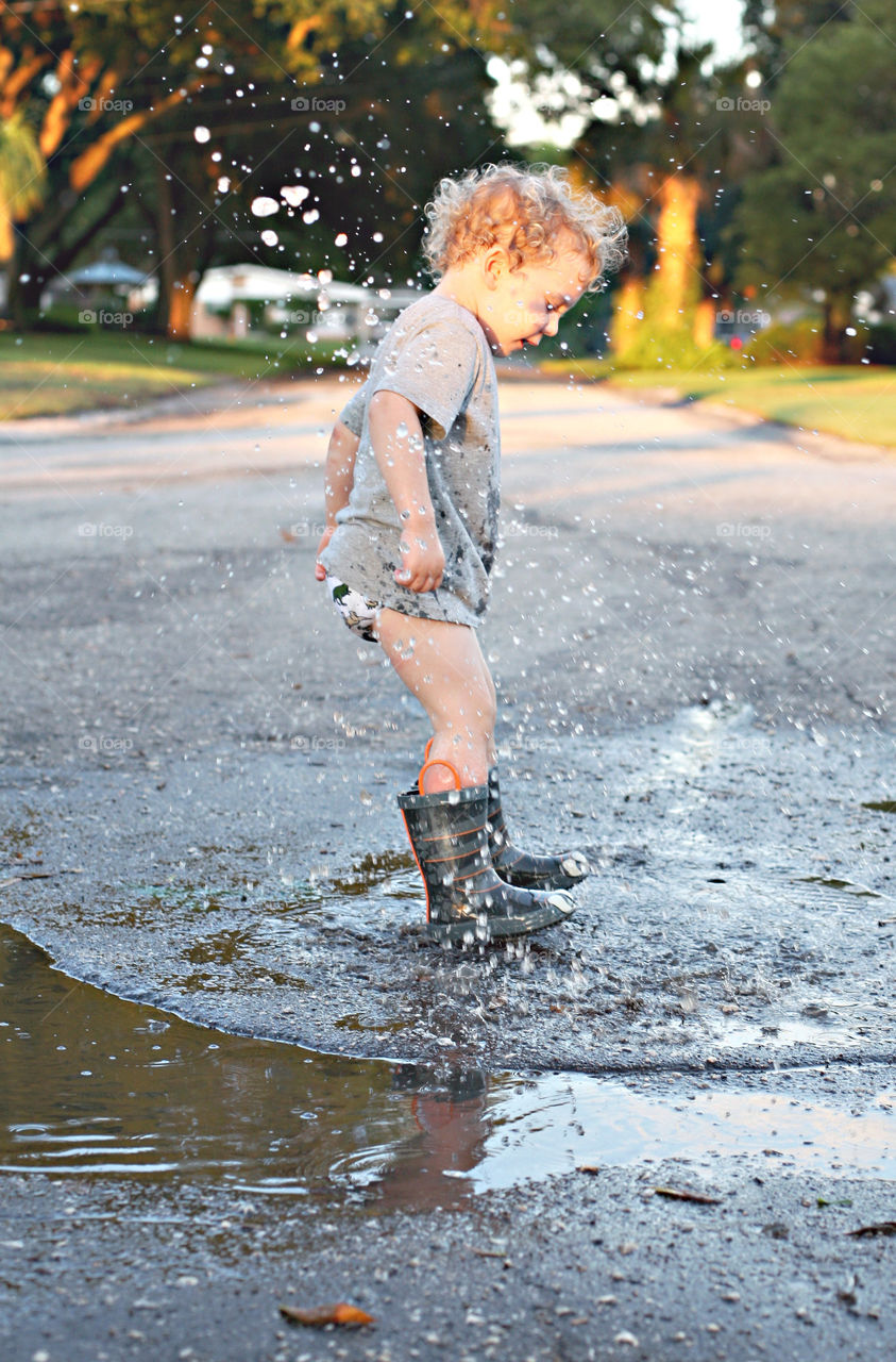 Boy jumping in small puddle
