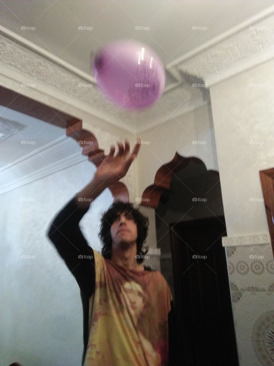 A young man plays with Ballons.