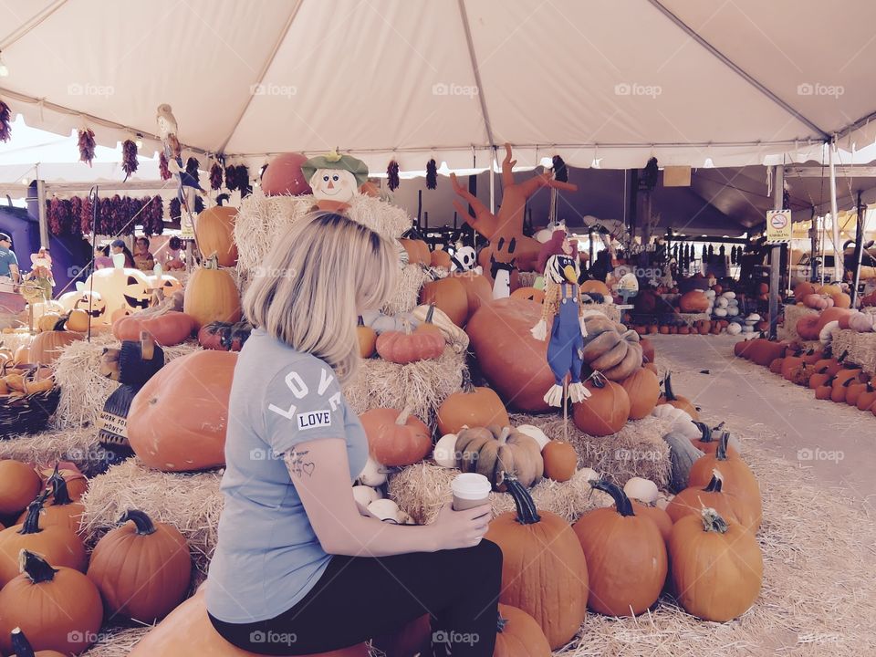 Woman at the pumpkin patch with Starbucks coffee