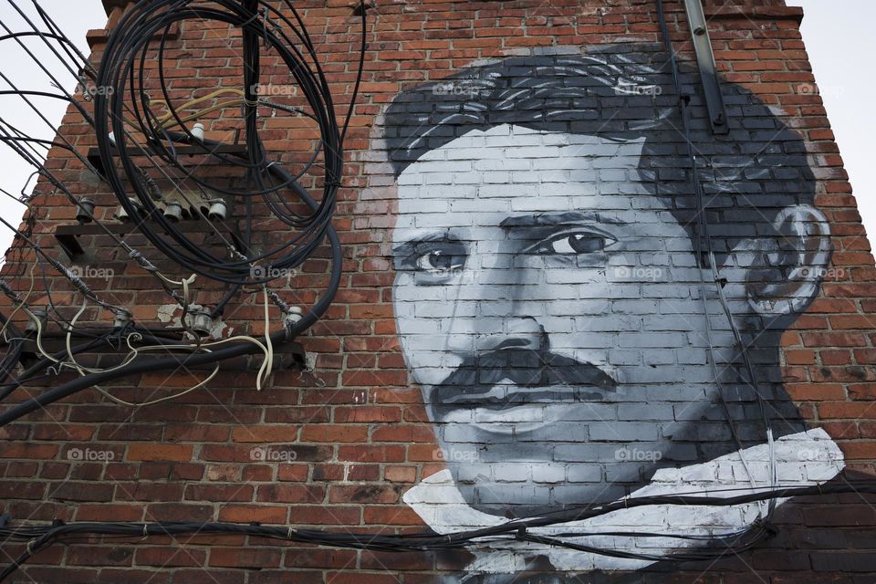 Nicola Tesla portrait on wall with electric wires . Nikola Tesla discovered electromagnetic field theory