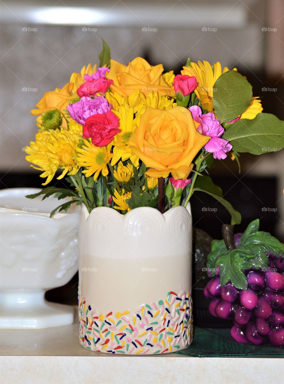 Birthday countertop springtime flowers in a colorful white vas