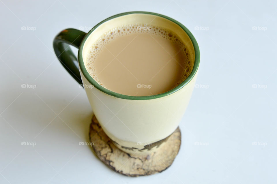 Mug of coffee on a natural wooden coaster