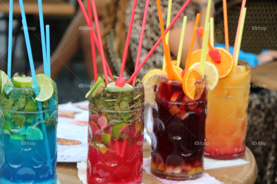 Colourful cocktails  with straws nicely arranged on the table to catch the eyes of by-passers 