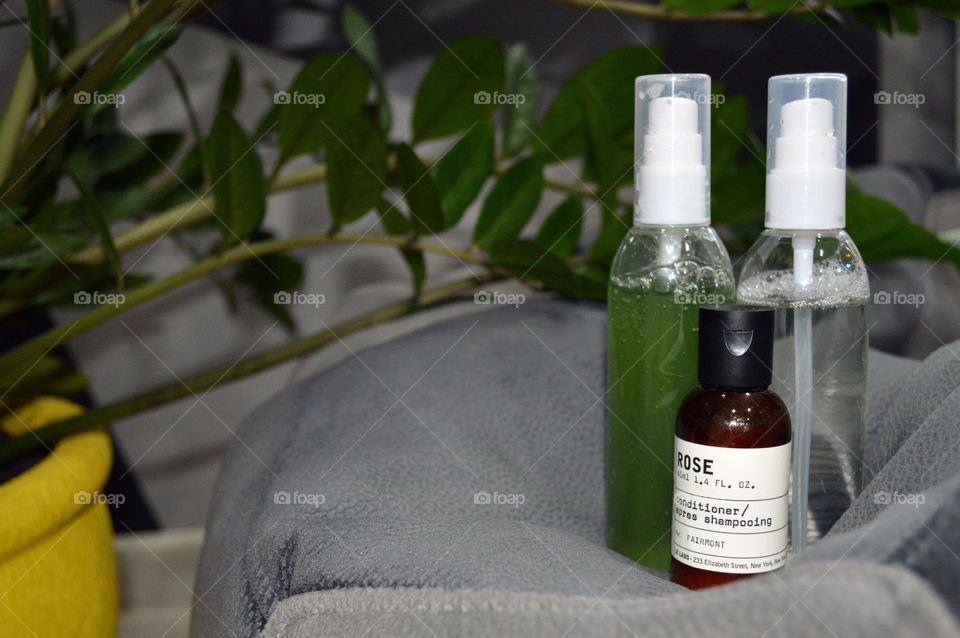 Jars with cream, shampoo and cosmetics on a background with green plants