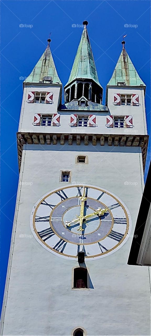 This is the medieval clock tower, the “Stadtturm” in the historic inner city of “Straubing”, “Niederbayern” or “Lower Bavaria”. It is located between “Ludwigsplatz” and “Theresienplatz”, the two main squares here. 2024. Hypnotic Productions