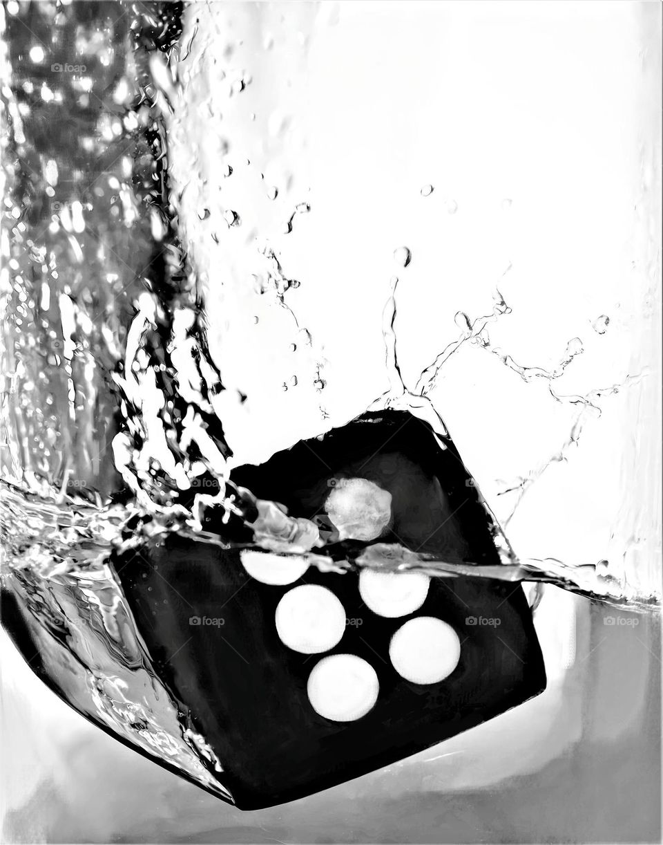 dice showing number six splashing in clear bright water black and white picture