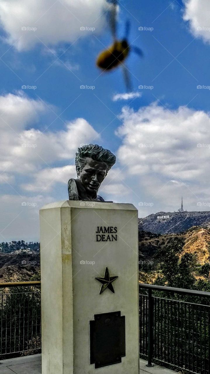 Monument to American film star James Dean at the Griffith Observatory, Los Angeles. Dean has his back to the Hollywood sign.