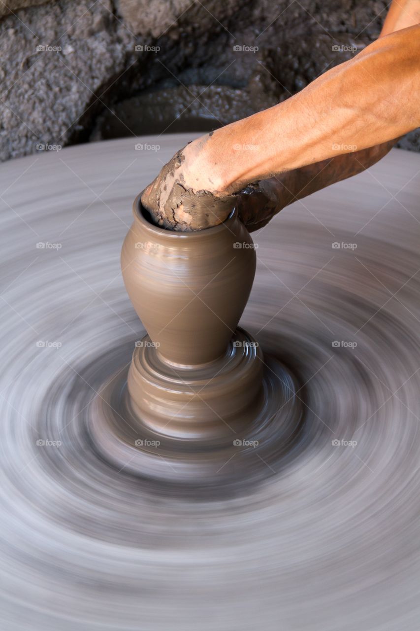 Hands creating pottery. Male hands creating pottery on a turning table