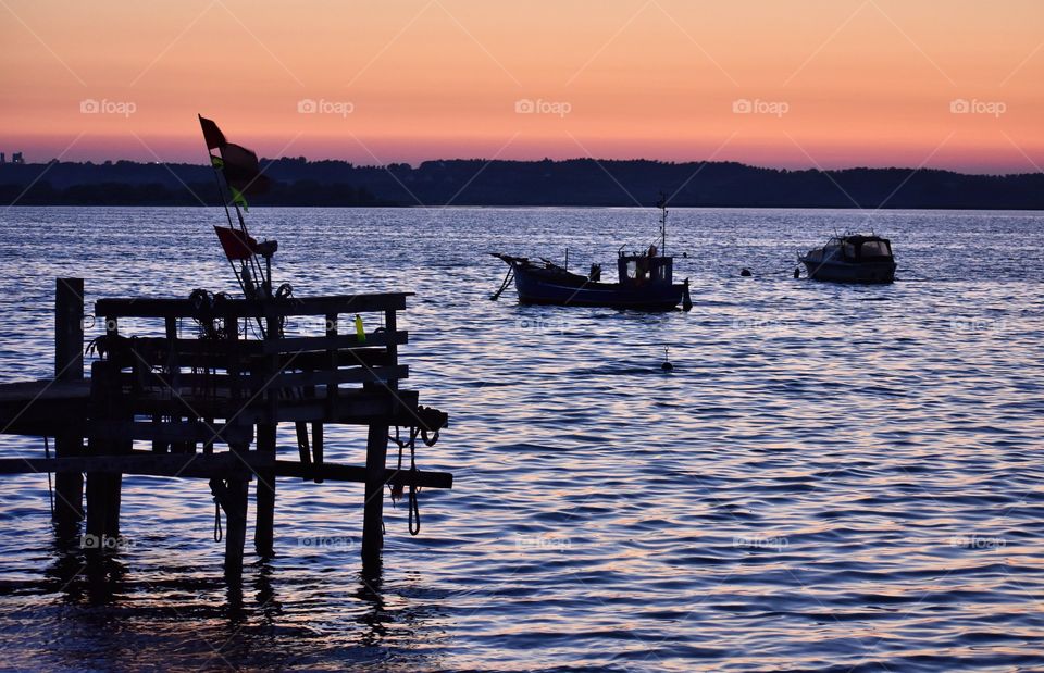 fishing at sunset time on the baltic sea in rewa, poland