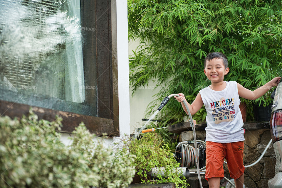 Boy watering plants in garden