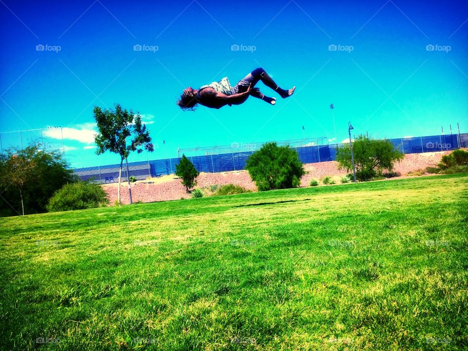Levitating flips . Kid in the park practicing his flips 