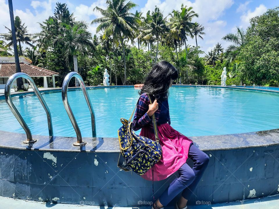 A girl sitting on the pool