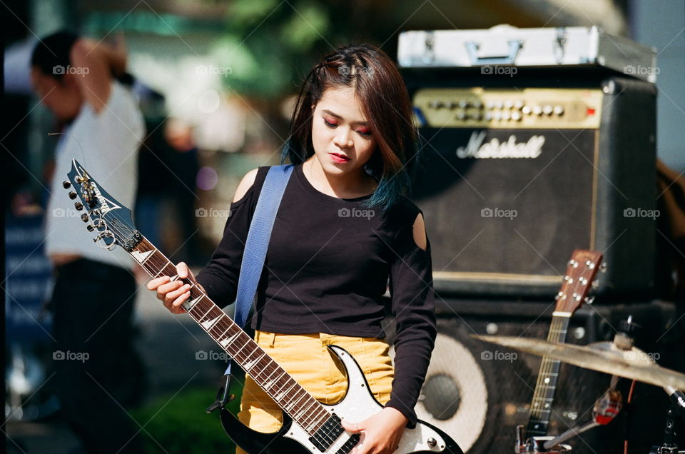 A girl with her guitar playing on the street