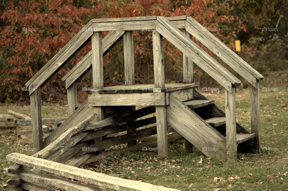 This is a set of stairs going over the wooden fence on a cool breezy autumn day in Brown County State Park.