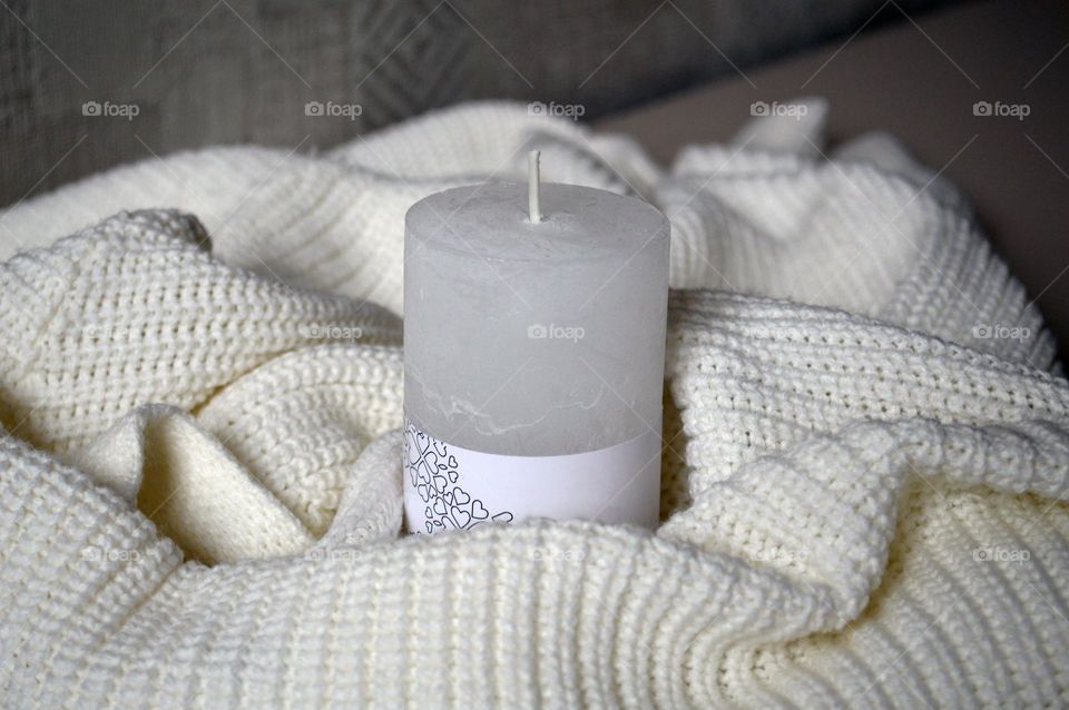 White candle on a knitted background