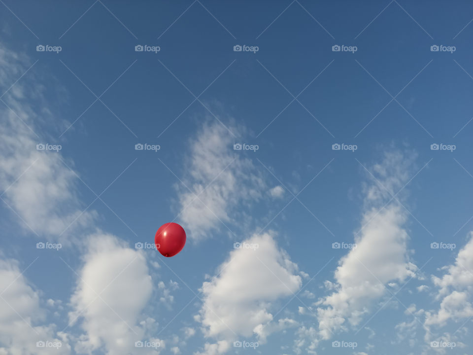 Red balloon Flying in blue sky.