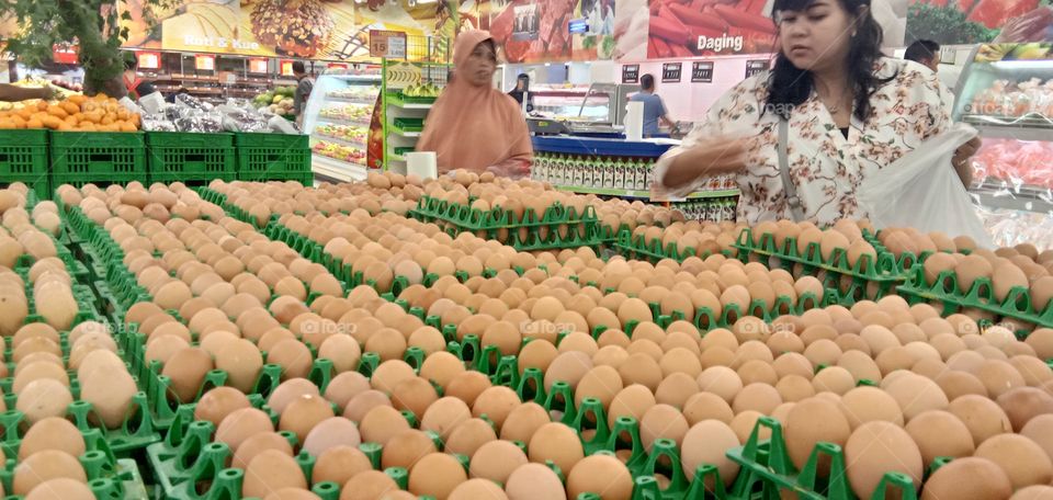 ibu ibu sedang membeli telur ayam di supermarket, buy eggs in market