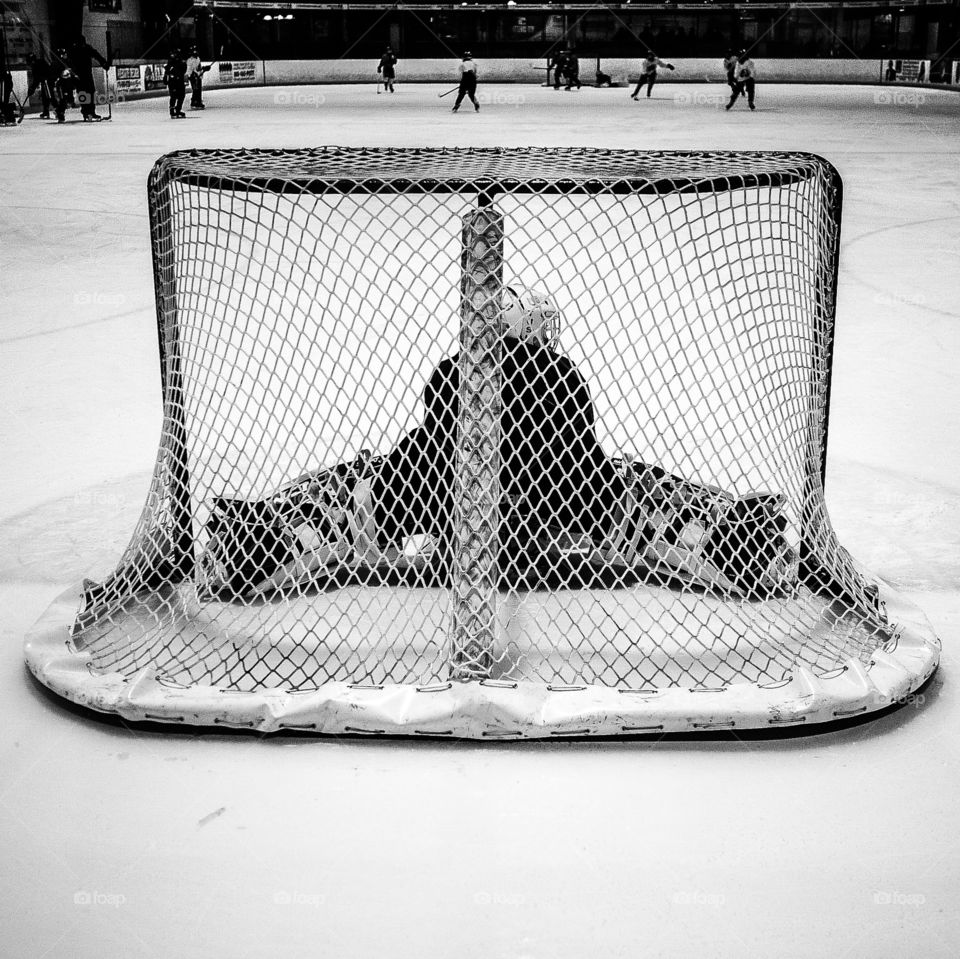 Stretch. Goalie stretching on the goal post