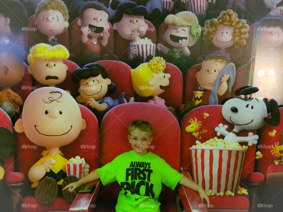 Small boy sitting near painted wall