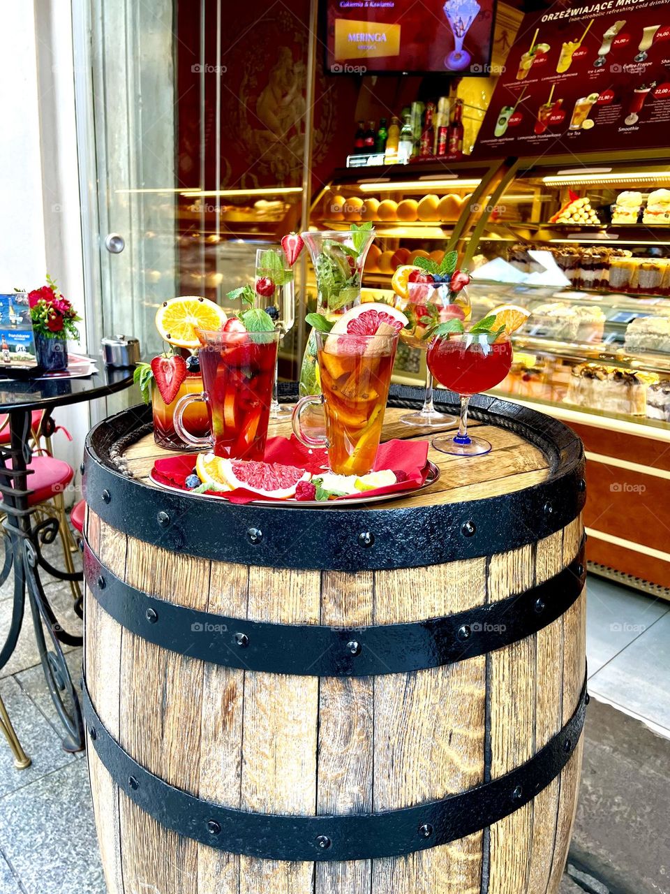 Table with a variety of colorful drinks in the form of a wooden barrel
