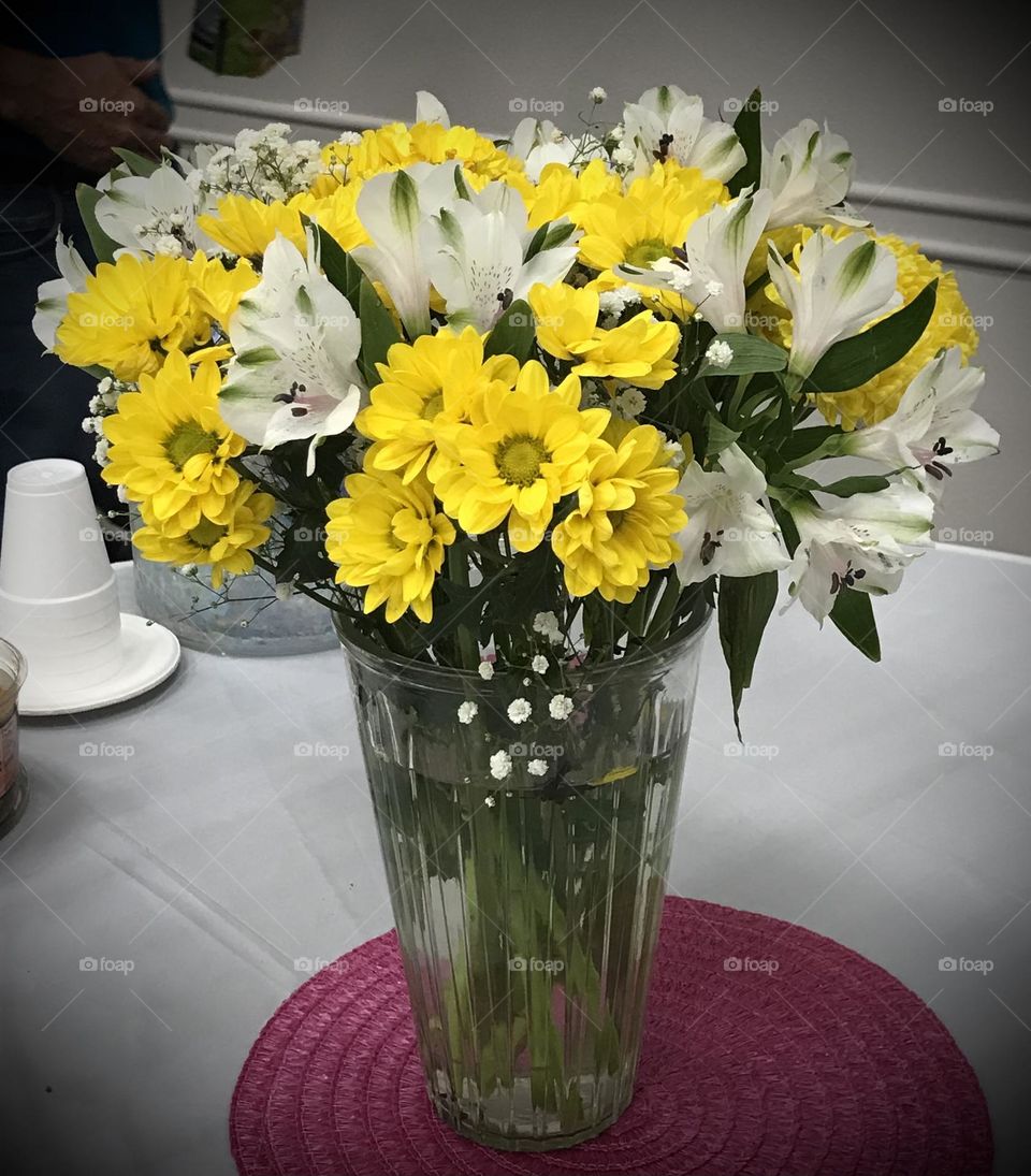 A bundle of beautiful flowers in a vase at church. They would make the room lively and refreshing.