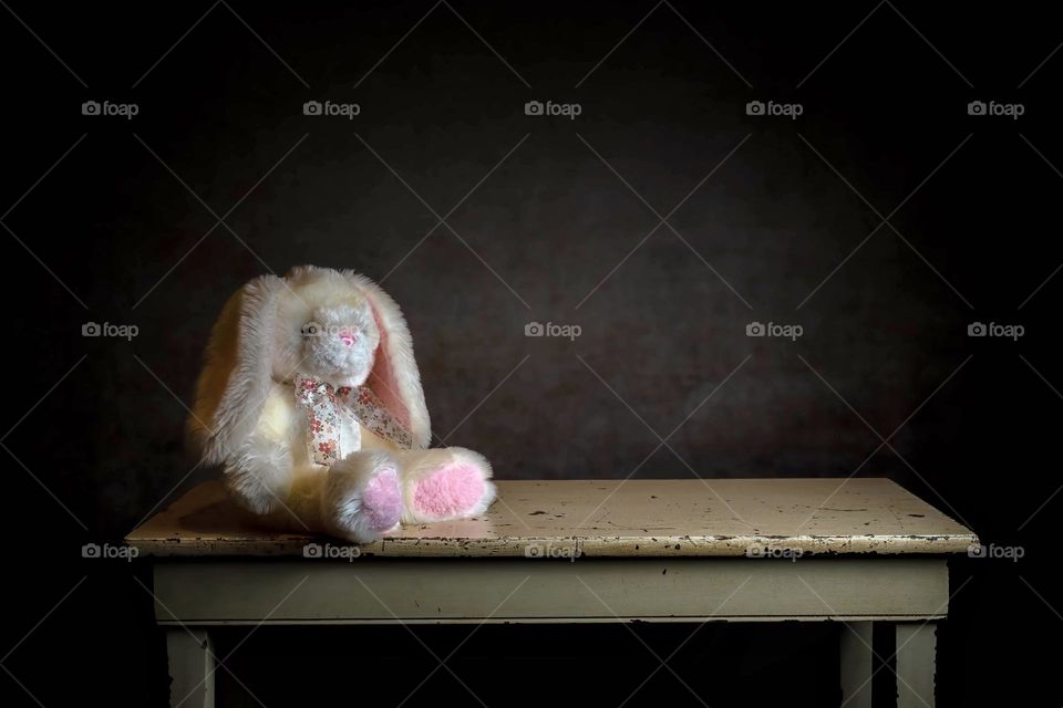 A lonely abandoned stuffed rabbit slumps on the stool. Image could symbolize many tough emotions that people may be grappling with. 