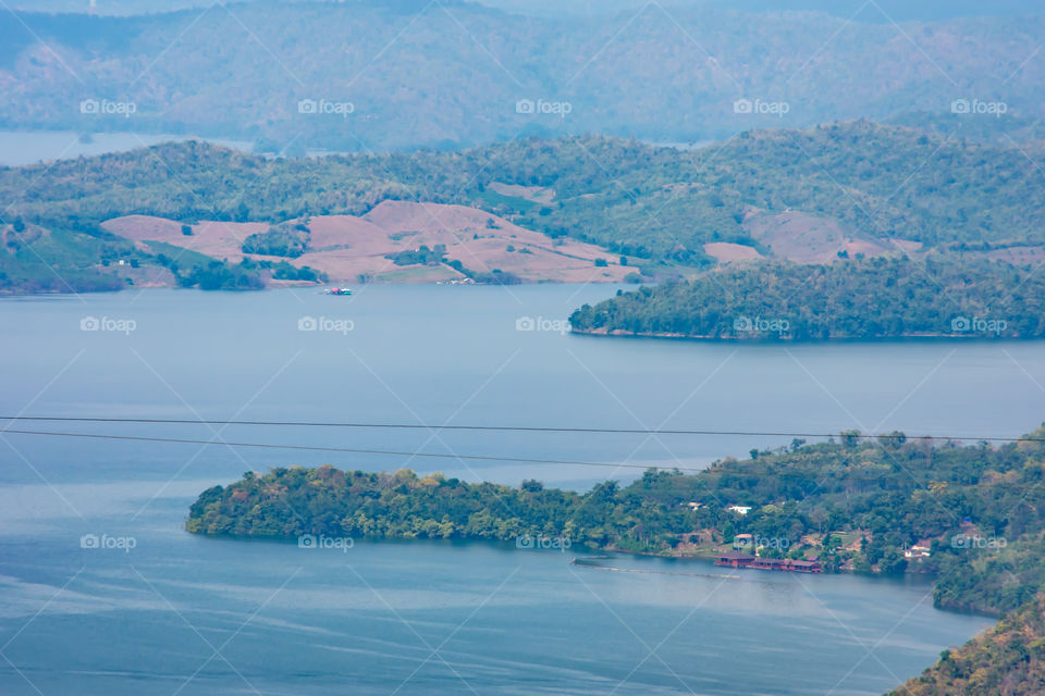 The beauty inside the dam and the houseboat on the bright sky at Sri Nakarin dam , Kanchana buri in Thailand.