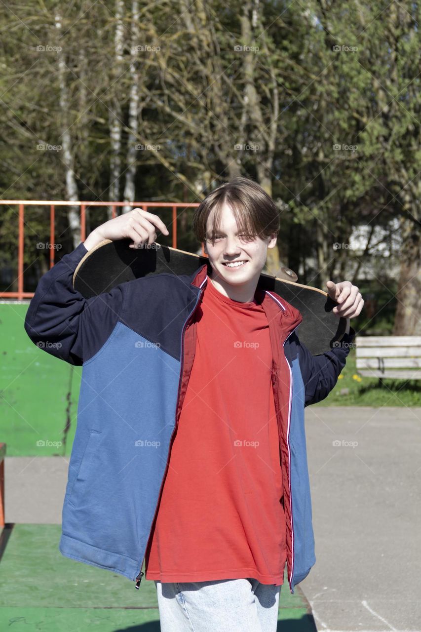 Hobbyist teenager goes in for sports, has fun and rides a skateboard in the park outdoors.