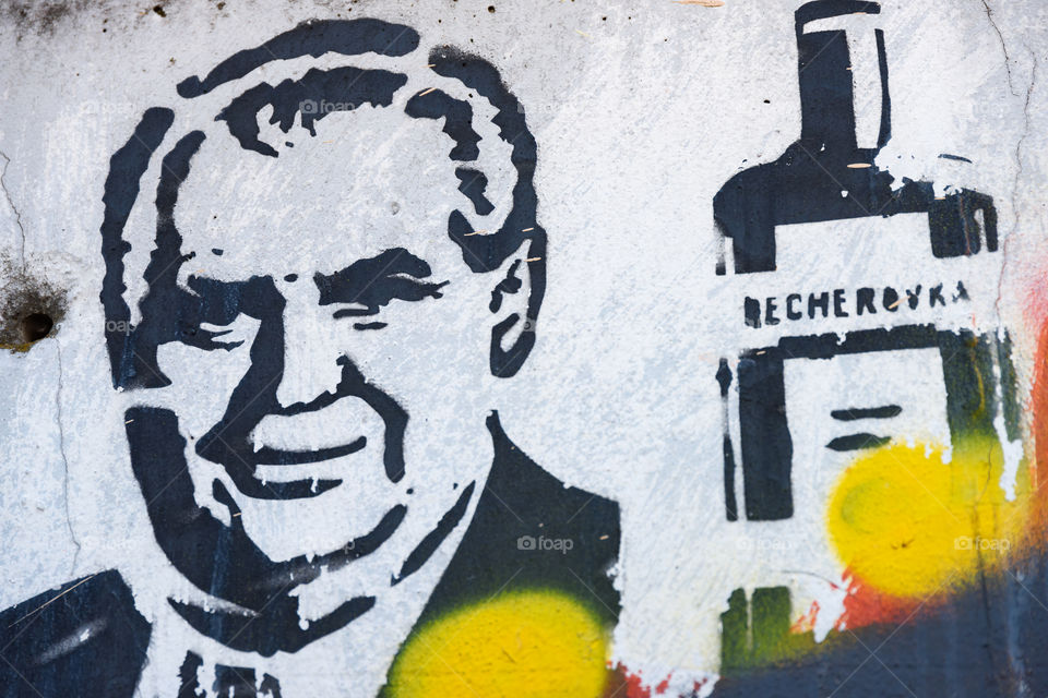 Prague, Czech Republic - July 3, 2017: Political graffiti painting on the wall at the outskirts of Prague portraying Czech President Miloš Zeman and Becherovka liquer bottle.