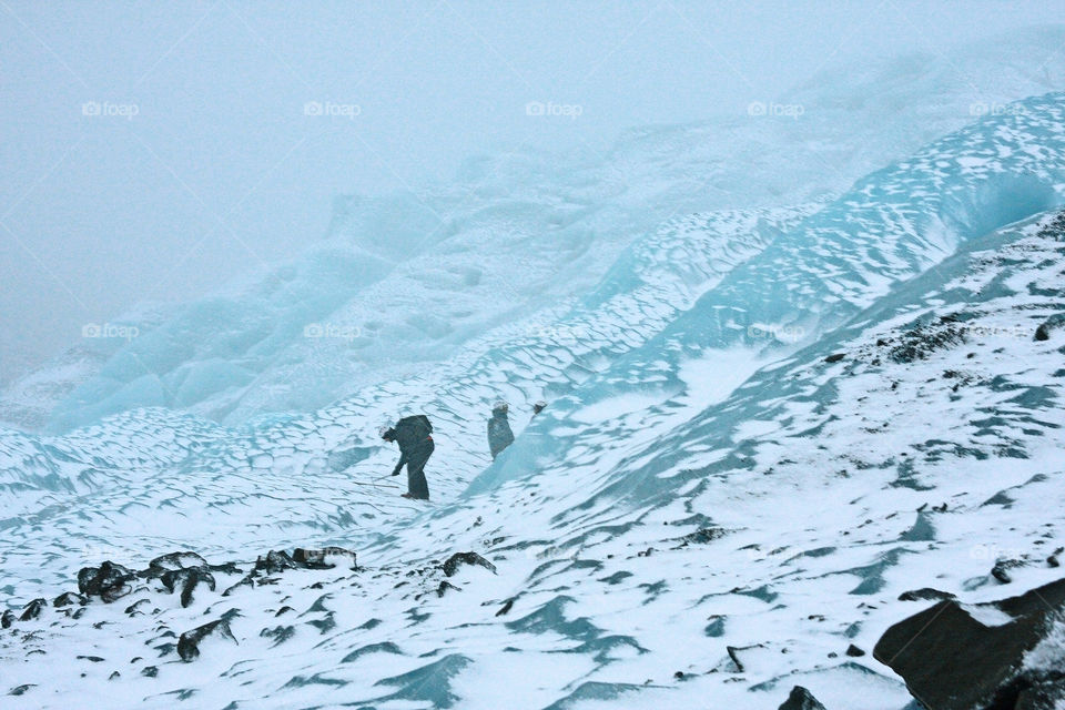 Person standing on blue ice mountain