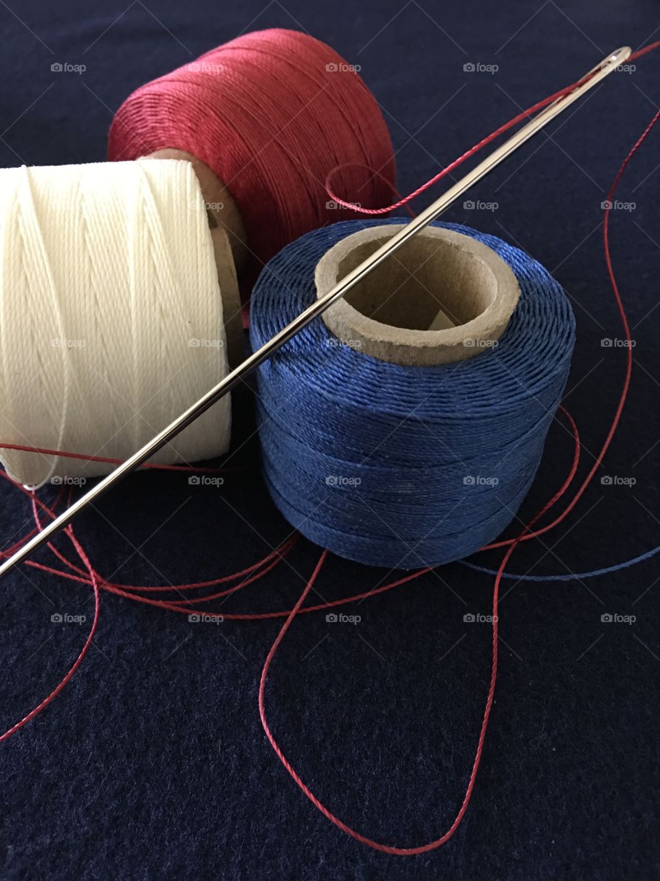 Red white and blue upholstery thread and needle