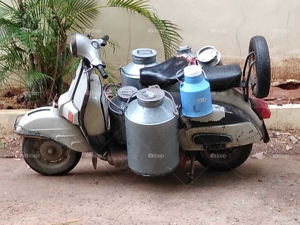 A scooter with milk cans
