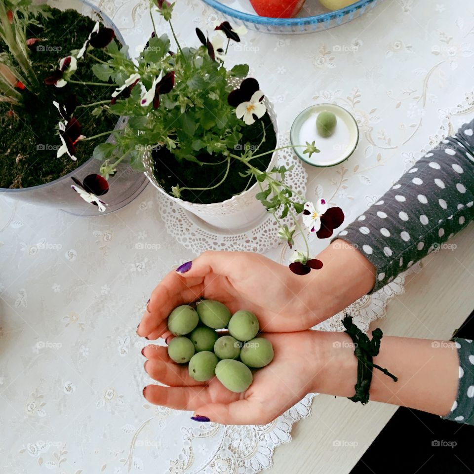 Person holding green fruit