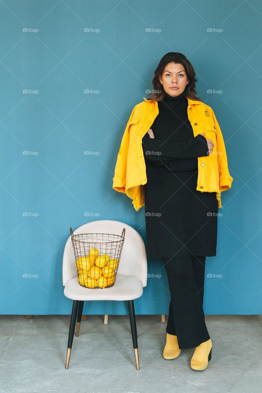 Young woman plus size in black and yellow outfit on blue background