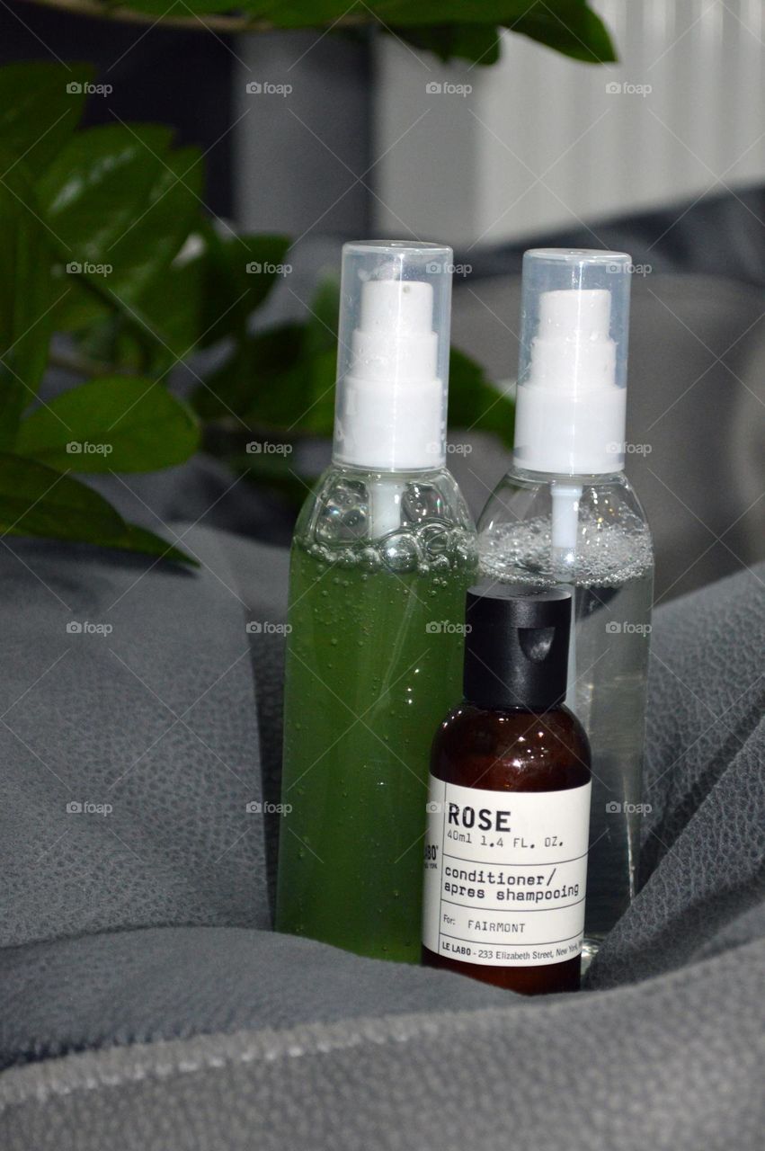 Jars with cream, shampoo and cosmetics on a background with green plants