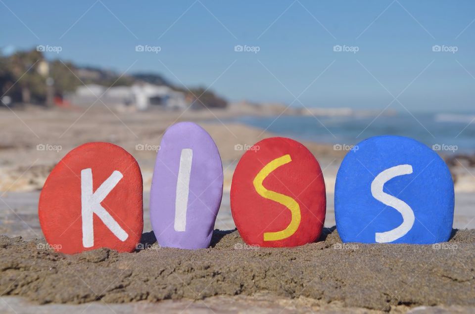 Kiss word on colourful stones