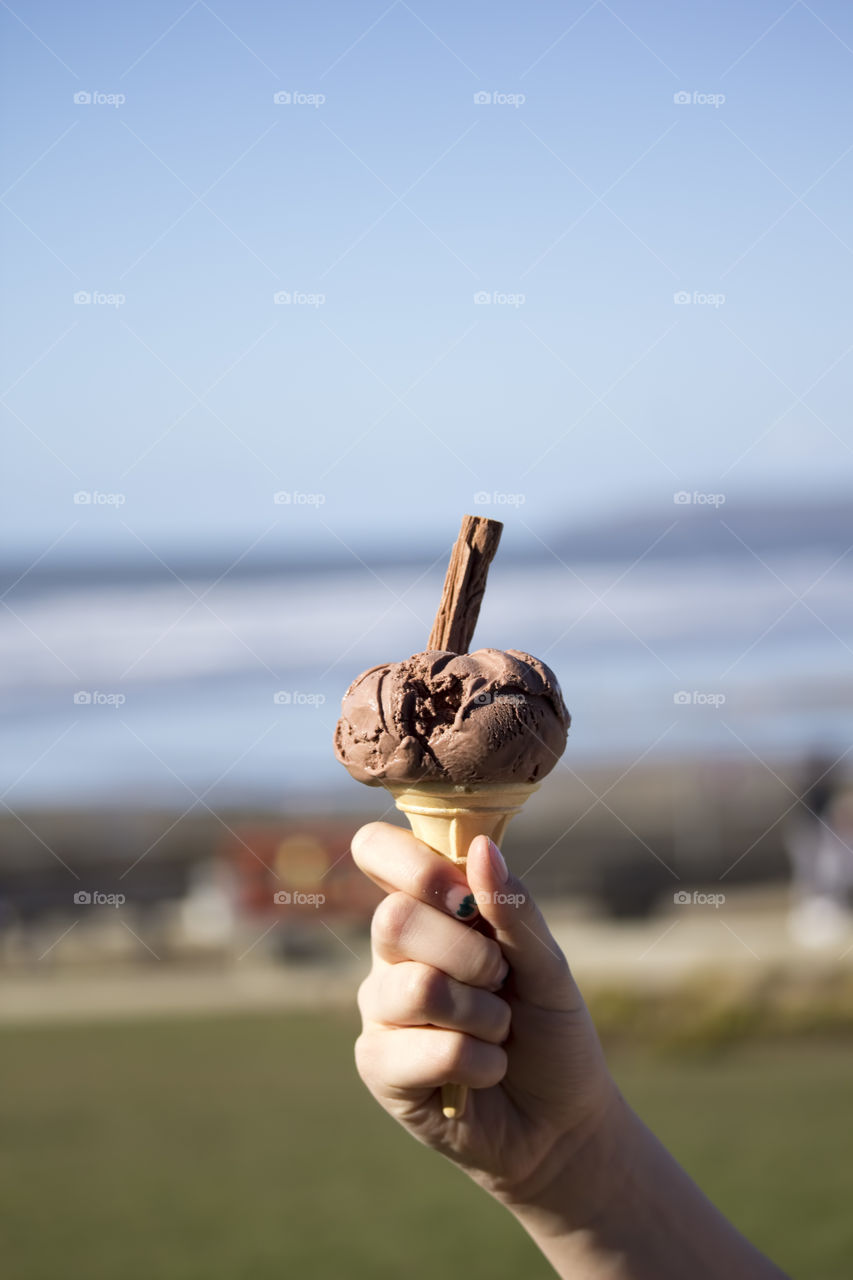 Hand holding ice cream cone in hand