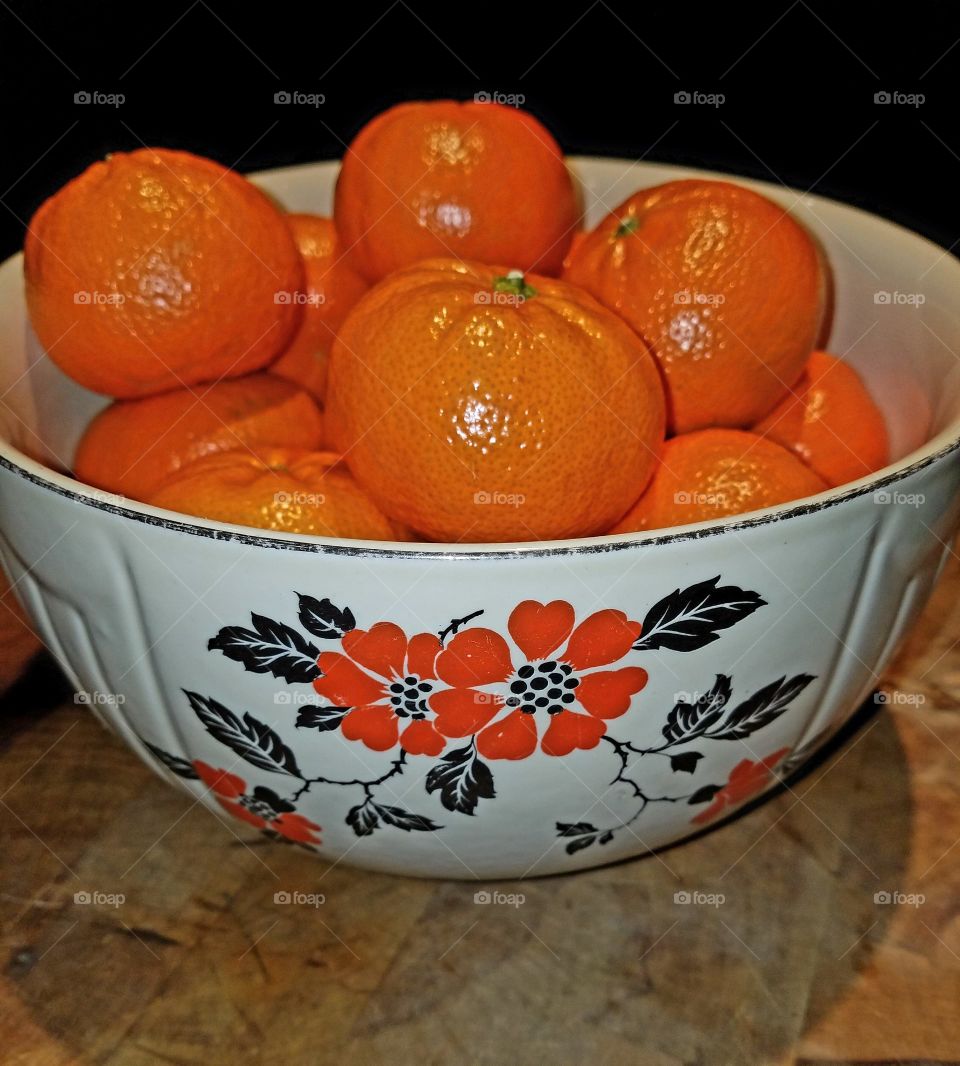 Fresh tangerines in painted bowl.