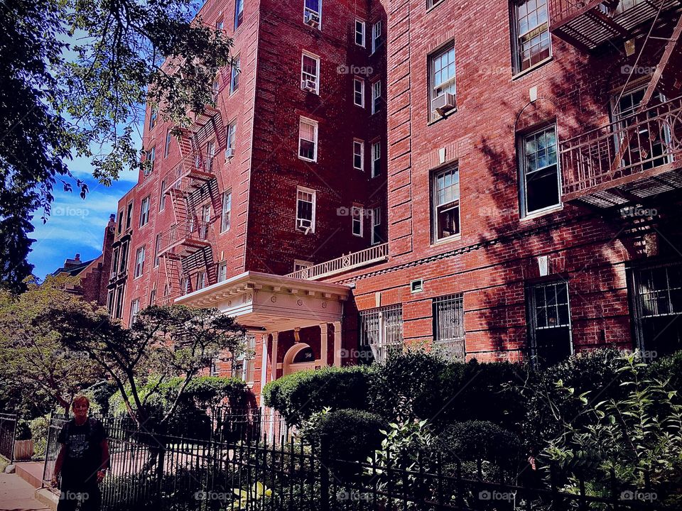 A Fort Greene, Bklyn brownstone styled as if from a bygone era: multiple offset levels, entrance halls with steps leading up to them, stucco ornaments around the windows, antique Greek style roofs, beautiful landscaping. 2020. Hypnotic Productions