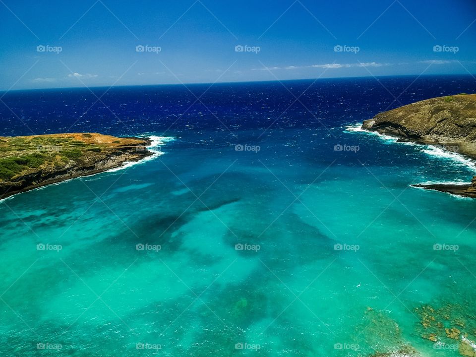 Ocean area in Hawaii with land on both sides of photo