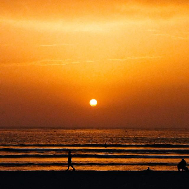a young boy runing near to the sea with a sunset at essaouira city in Morocco