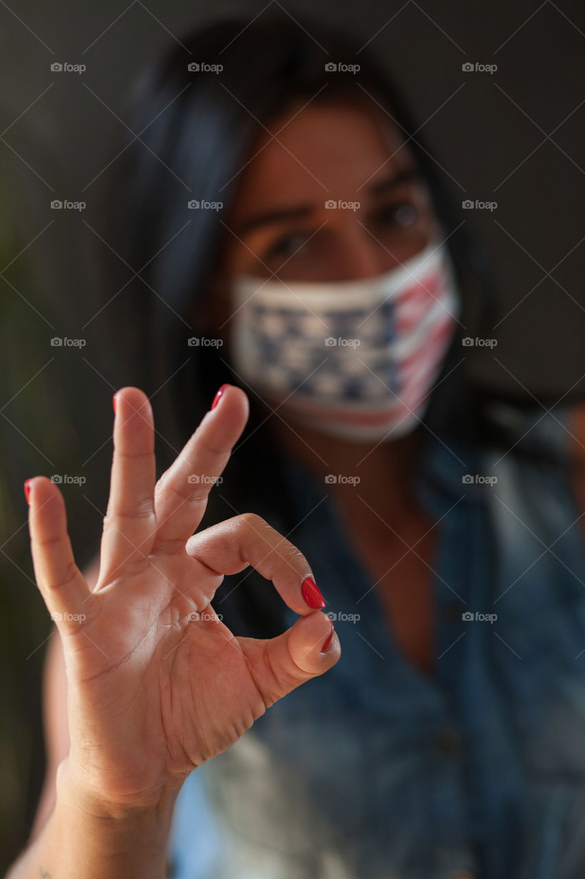 Beautiful brunette in a protective mask painted by the American flag. Independence Day in America. Flag. Love. A life. The mask is made by hand