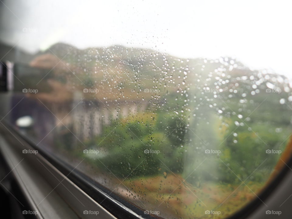 View outside the window of a train in the Scottish Highlands on a rainy day.
