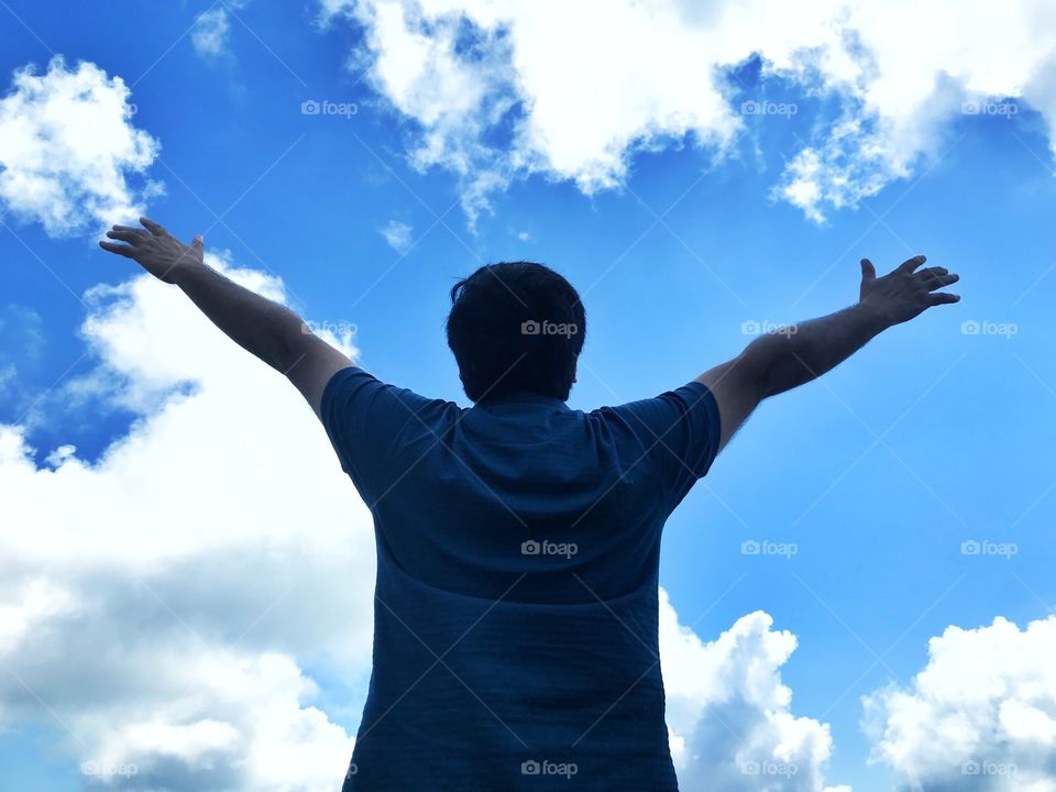 A man lifted his hands and looking up to the sky