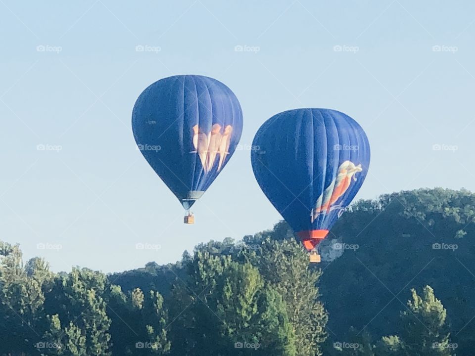 Blue balloons in the pale blue sky in France