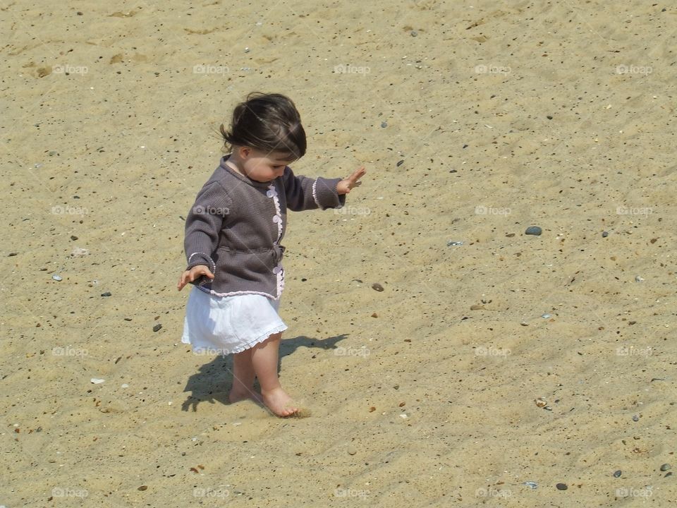 Felling the sand on her feet.