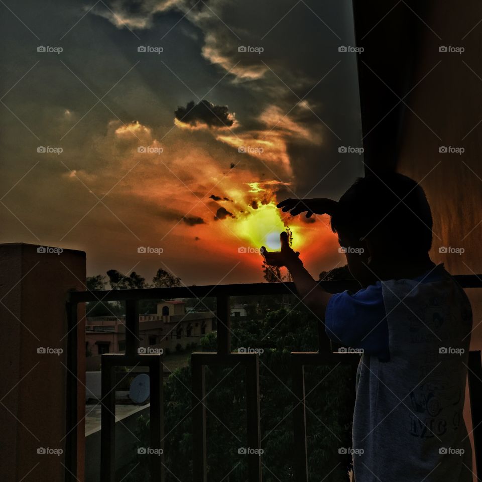 The true power lies in the hands of our Younger Generation. Its on us how do we teach them to handle it. This pic depicts a bit of it. 
If you look closely the Sun is crying out loud to save him. Its not an edit. The eyes and nose appeared itself.